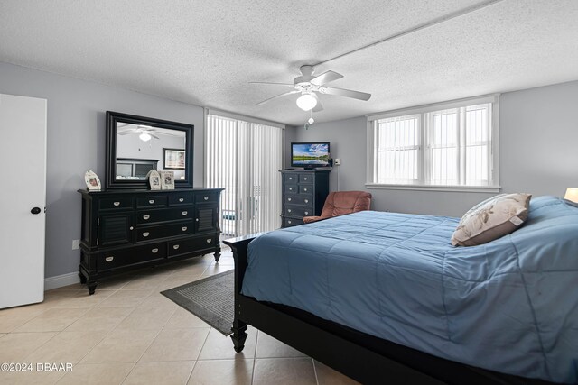 tiled bedroom featuring ceiling fan and a textured ceiling