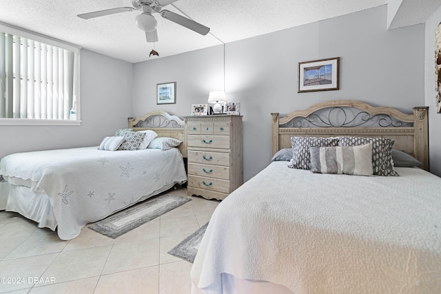 bedroom with a textured ceiling, ceiling fan, and light tile patterned floors