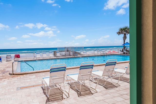 view of pool featuring a water view and a patio area