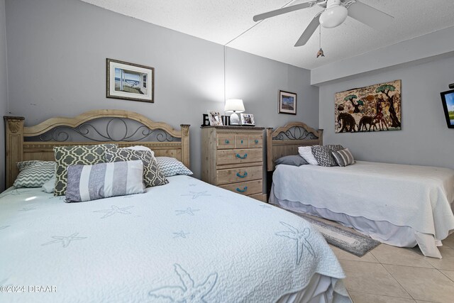 bedroom featuring a textured ceiling, ceiling fan, and light tile patterned floors