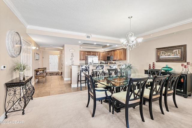 dining space featuring a chandelier, crown molding, a textured ceiling, light carpet, and a tray ceiling