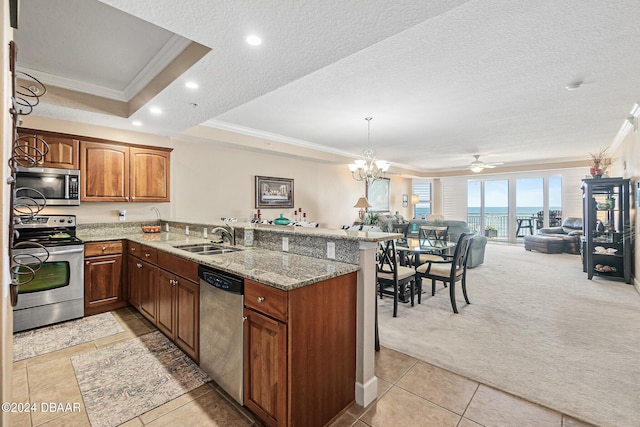 kitchen featuring light carpet, sink, kitchen peninsula, appliances with stainless steel finishes, and a textured ceiling