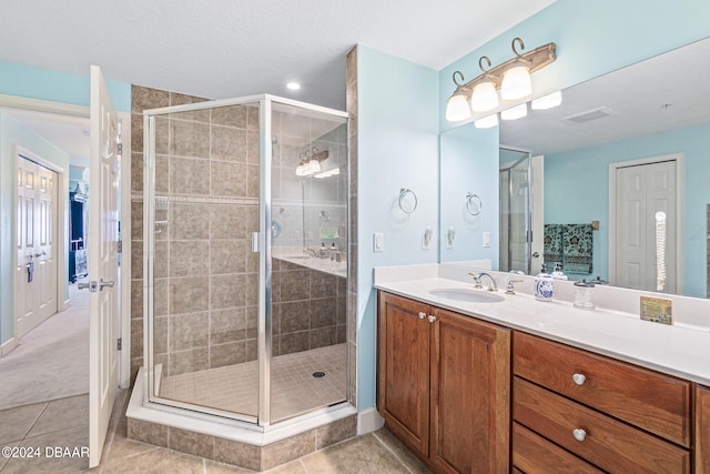 bathroom with tile patterned flooring, an enclosed shower, and vanity