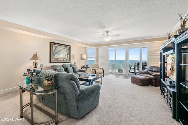 living room with ceiling fan, crown molding, a water view, and carpet floors