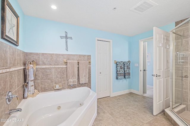 bathroom featuring tile walls, tile patterned floors, and separate shower and tub