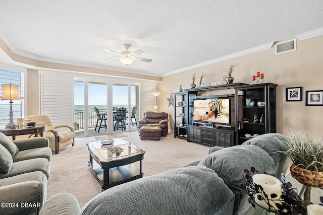 living room with a textured ceiling, light carpet, ceiling fan, and crown molding