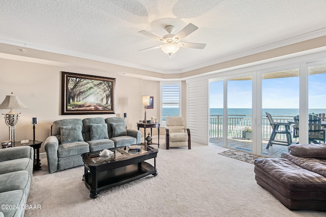 carpeted living room with a water view, a textured ceiling, and crown molding