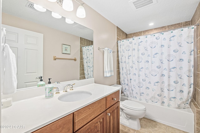 full bathroom with tile patterned flooring, a textured ceiling, shower / tub combo with curtain, vanity, and toilet