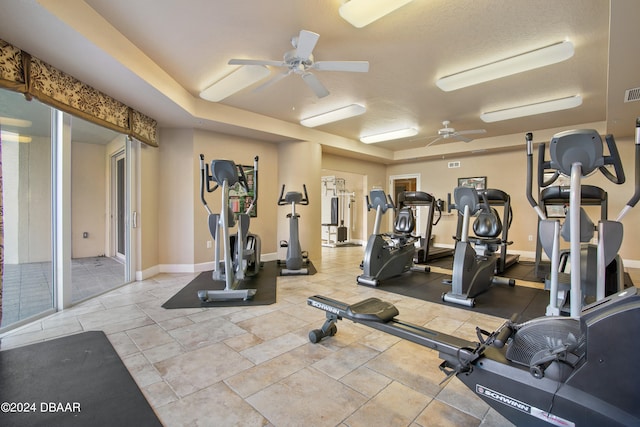 exercise room with ceiling fan and a textured ceiling