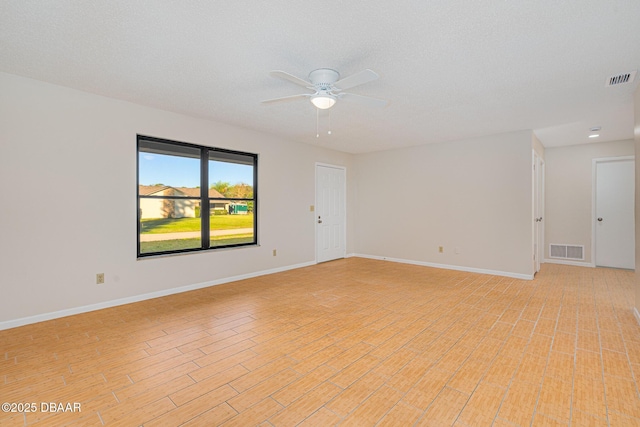 empty room featuring visible vents, baseboards, and light wood-style floors