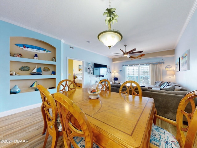 dining space featuring ornamental molding, light hardwood / wood-style floors, ceiling fan, and built in features