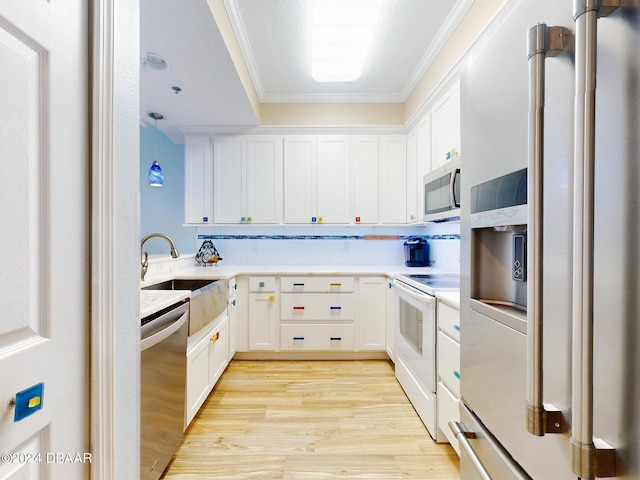 kitchen featuring light hardwood / wood-style flooring, white cabinetry, ornamental molding, and stainless steel appliances