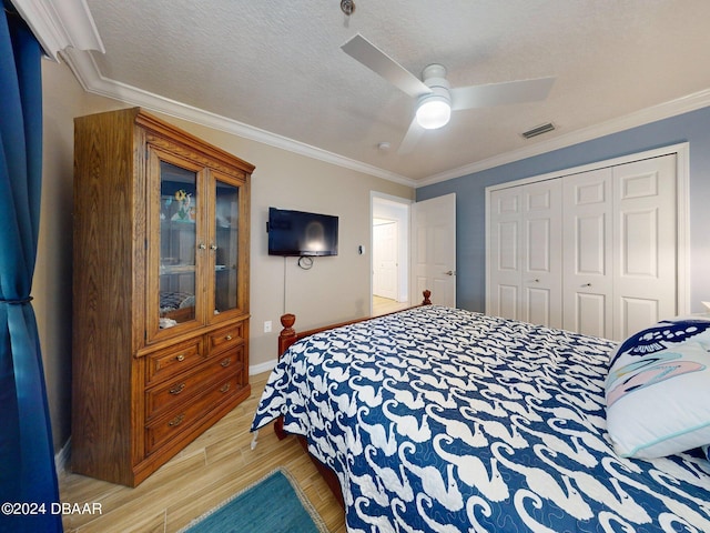 bedroom with light hardwood / wood-style floors, ceiling fan, a closet, and ornamental molding