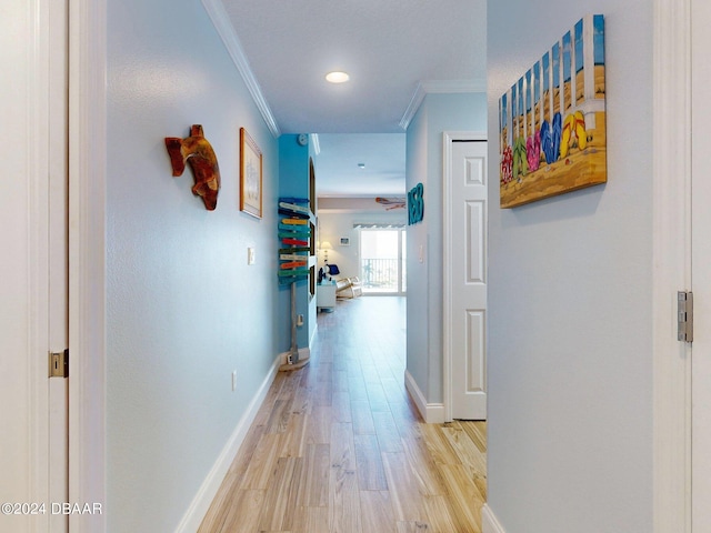 corridor with crown molding and light hardwood / wood-style flooring