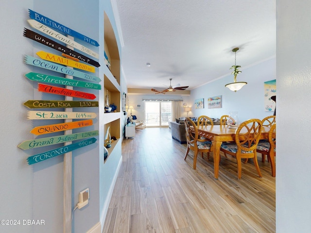 dining room with light wood-type flooring, ceiling fan, and crown molding