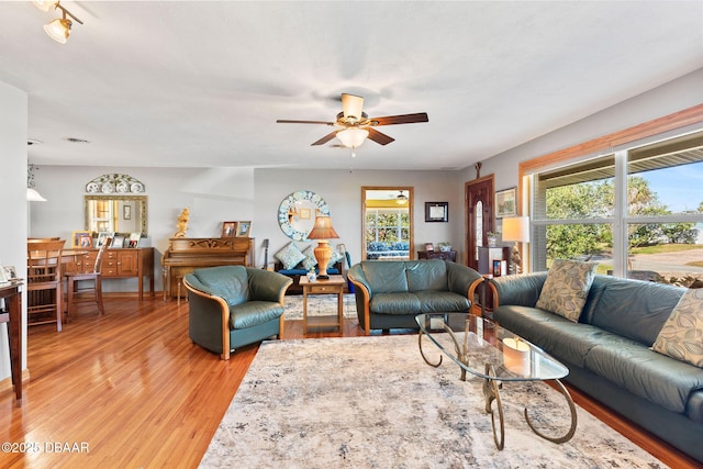 living room with light hardwood / wood-style floors and ceiling fan