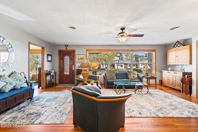 living room with light hardwood / wood-style flooring, plenty of natural light, and ceiling fan