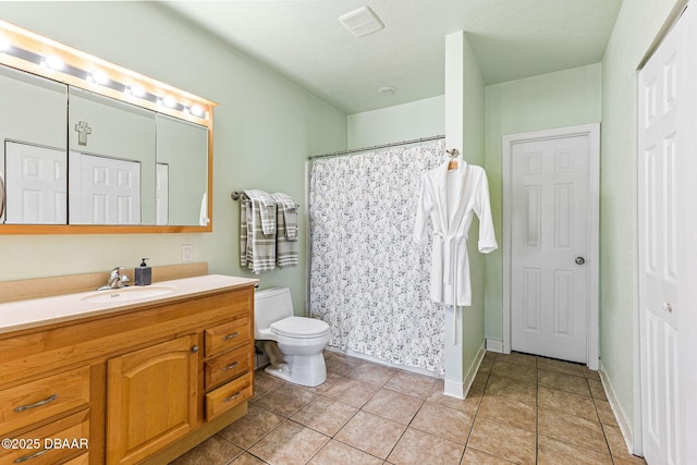 bathroom featuring a shower with shower curtain, vanity, toilet, and tile patterned flooring