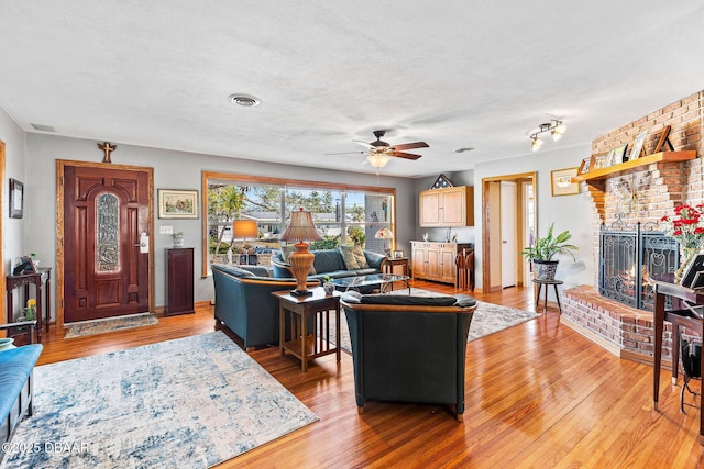 living room with hardwood / wood-style floors, a textured ceiling, and a fireplace