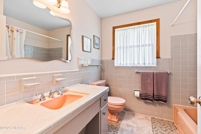 bathroom with vanity, toilet, tile patterned flooring, and tile walls