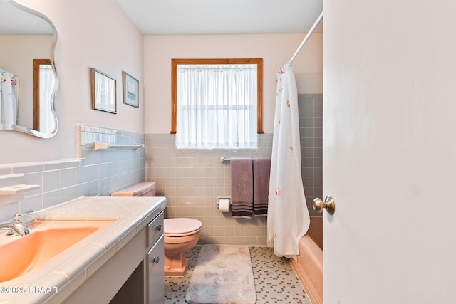 full bathroom with tile patterned floors, vanity, toilet, and tile walls