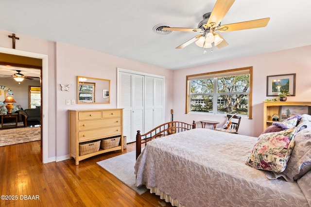 bedroom featuring hardwood / wood-style flooring, ceiling fan, and a closet