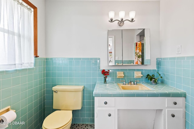 bathroom featuring vanity, toilet, and tile walls