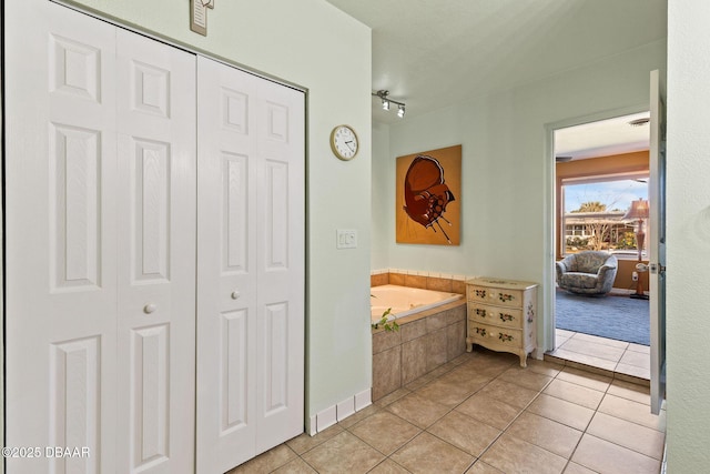 bathroom featuring tile patterned flooring and tiled tub