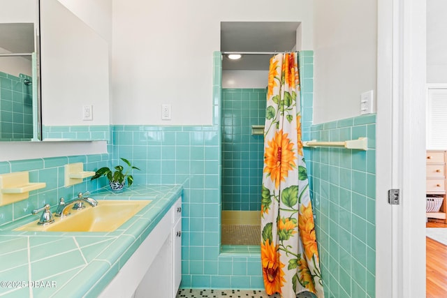 bathroom with vanity, a shower with shower curtain, and tile walls