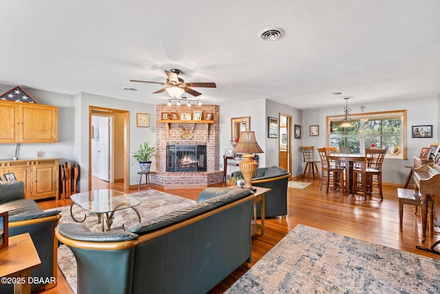 living room with ceiling fan, a fireplace, and dark hardwood / wood-style floors