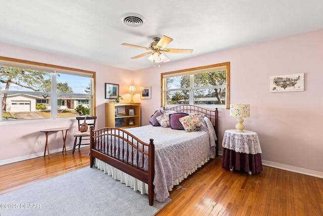 bedroom featuring multiple windows, ceiling fan, and light wood-type flooring