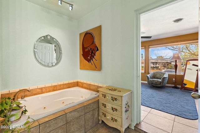 bathroom with tiled tub and tile patterned floors