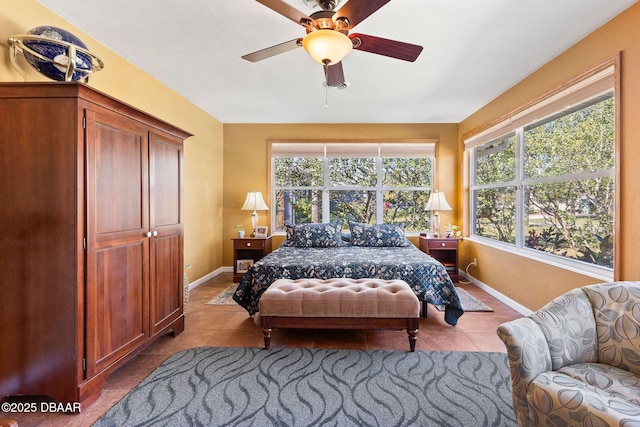 tiled bedroom featuring ceiling fan and multiple windows