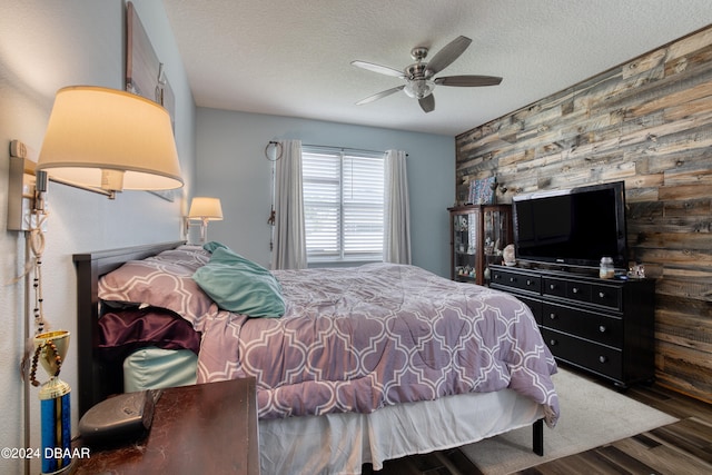 bedroom featuring ceiling fan, a textured ceiling, and dark hardwood / wood-style flooring