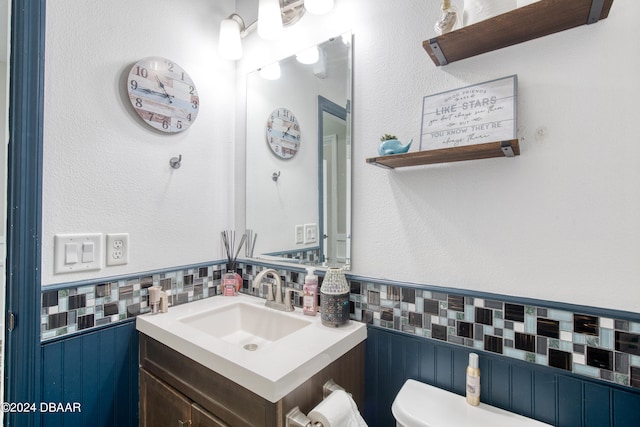 bathroom featuring vanity, tasteful backsplash, and toilet