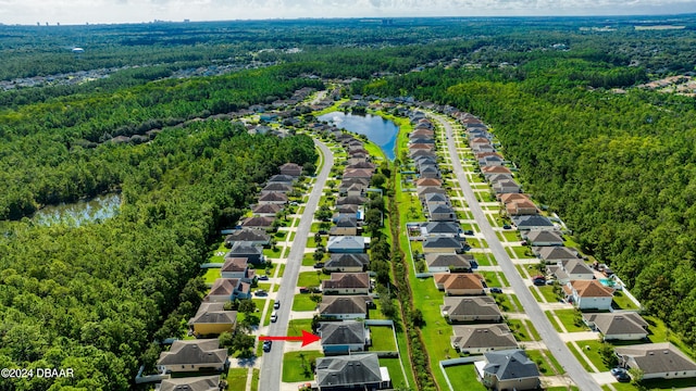 birds eye view of property featuring a residential view, a water view, and a wooded view