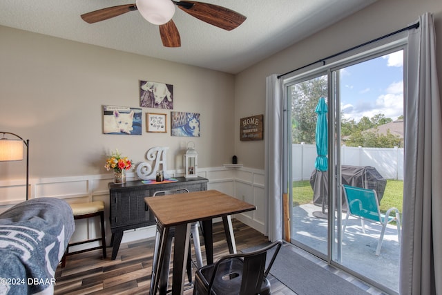 home office featuring a wainscoted wall, a ceiling fan, a textured ceiling, and wood finished floors