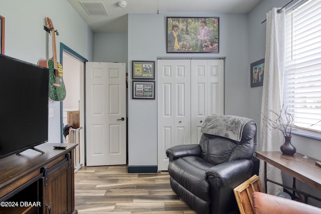 living area featuring a textured ceiling and light hardwood / wood-style flooring