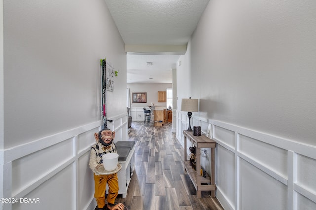 corridor featuring dark hardwood / wood-style flooring and a textured ceiling