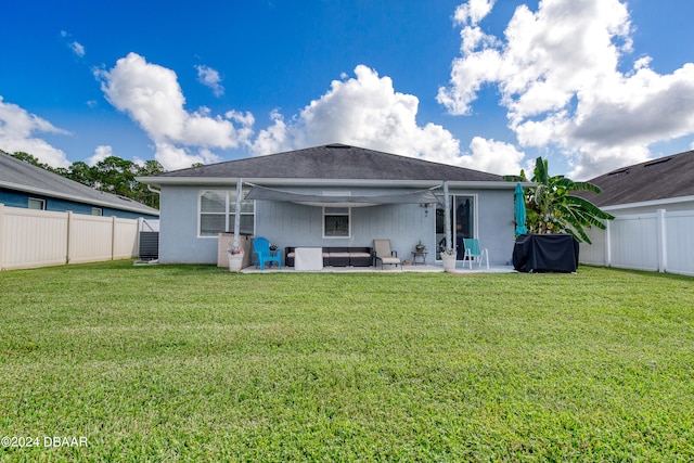 back of house featuring a lawn and a patio