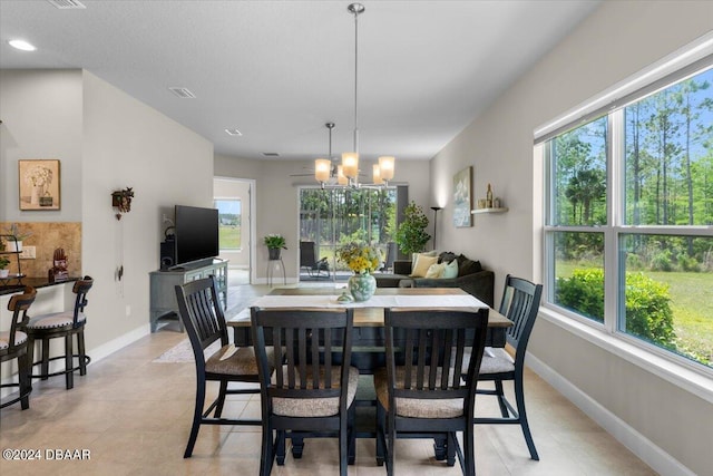 tiled dining room with a chandelier