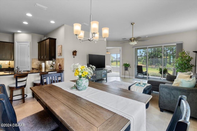 dining area with light tile patterned flooring and ceiling fan with notable chandelier