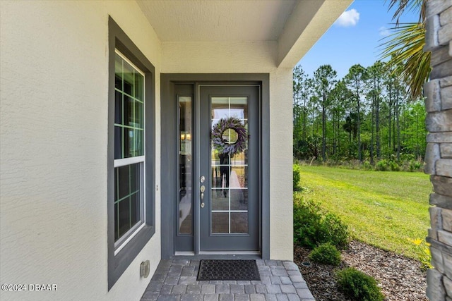 property entrance featuring a lawn