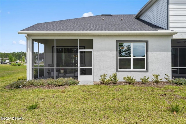 back of property featuring a sunroom and a lawn