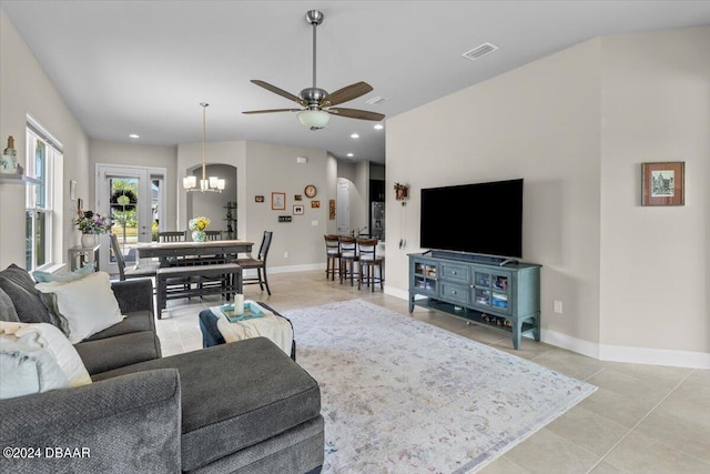 living room with ceiling fan with notable chandelier and light tile patterned floors