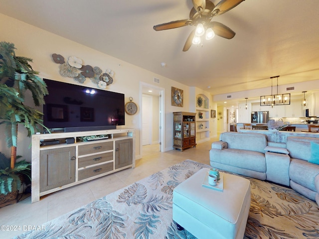 tiled living room featuring ceiling fan with notable chandelier and built in features