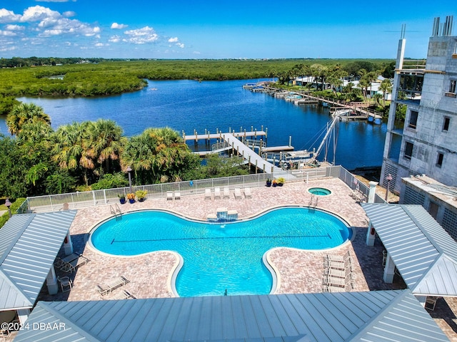 view of swimming pool with a patio area and a water view