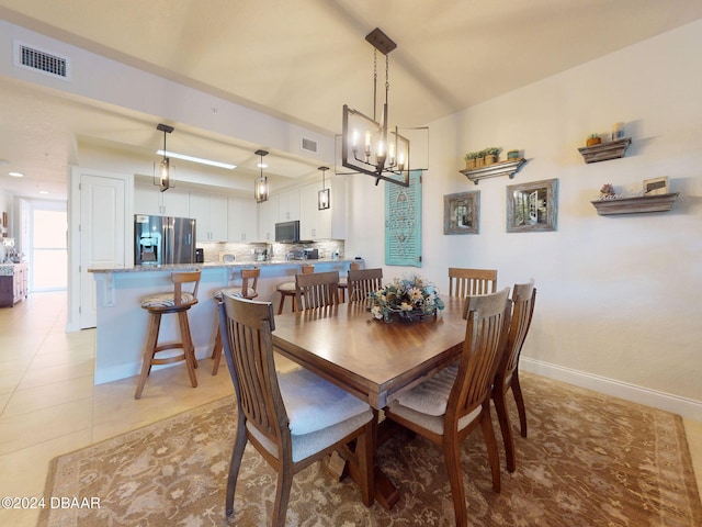 tiled dining space featuring a notable chandelier