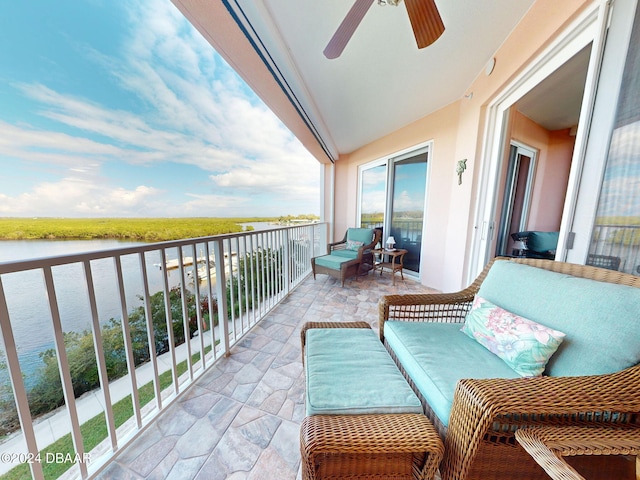 balcony with a water view, ceiling fan, and an outdoor hangout area