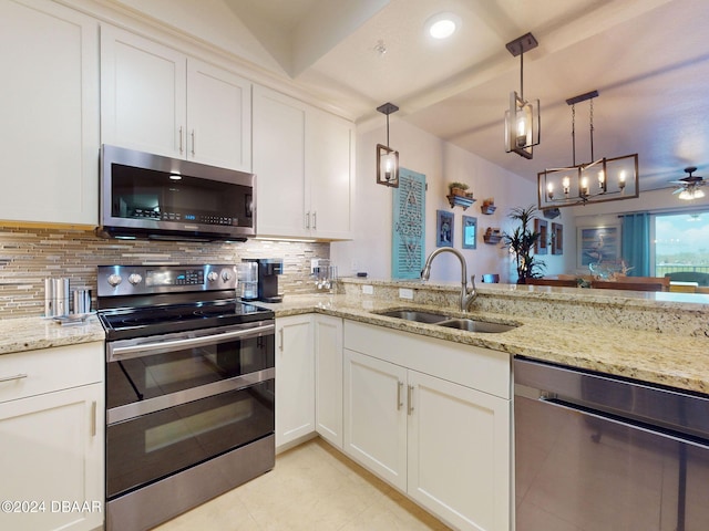 kitchen with sink, appliances with stainless steel finishes, decorative light fixtures, and white cabinets